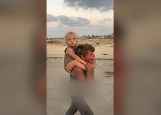 La historia detrás de la imagen viral de un niño palestino que lleva cargando a su hermanito en Gaza